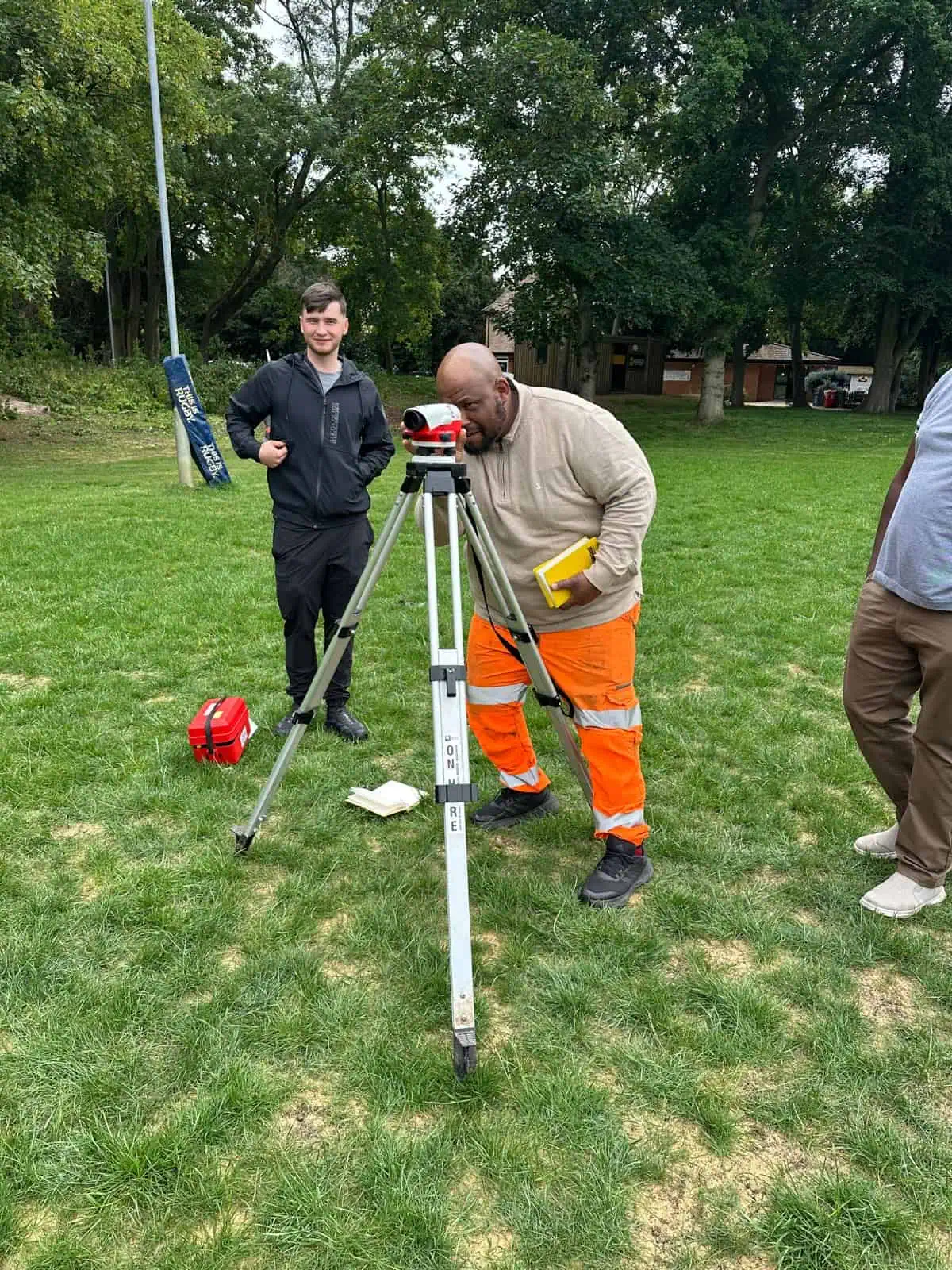 Students learning levelling and setting out skills during practical site surveying training.